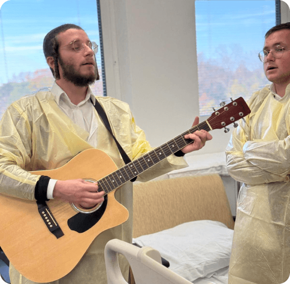 Volunteer playing guitar for a patient